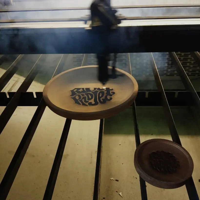 Grafir laser kaligrafi di tatakan kayu bundar