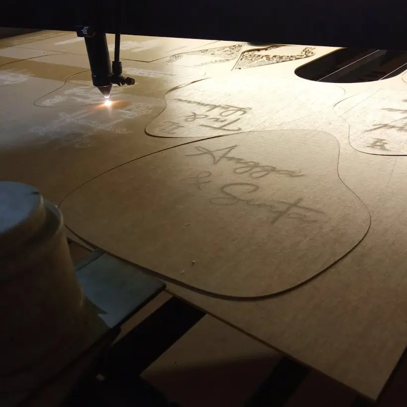 Sinar laser memotong pola di papan